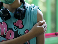 A nurse applies the first dose of Covid19 Pfizer vaccine to a child during mass vaccination campaign for infants 12 to 14 years of age, with...