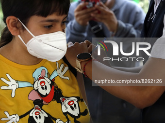 A nurse applies the first dose of Covid19 Pfizer vaccine to a child during mass vaccination campaign for infants 12 to 14 years of age, with...