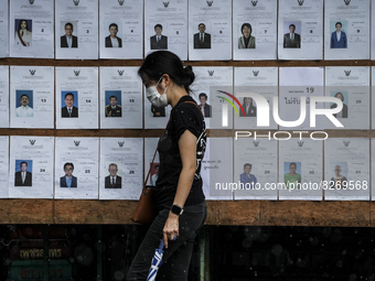 A woman looks for her name prior to casting her ballot in the Bangkok governor election at a polling station in Bangkok, Thailand, 22 May 20...