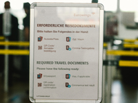 a sign of travel documents required is seen in front of Eurowings checkin counter at Cologne & Bonn airport on May 25, 2022 as Germany will...