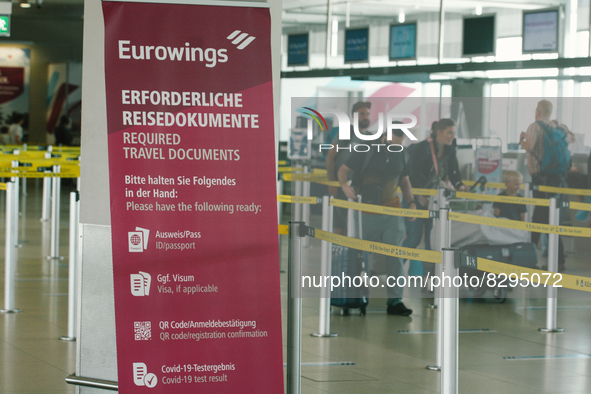 a sign of travel documents required is seen in front of Eurowings checkin counter at Cologne & Bonn airport on May 25, 2022 as Germany will...