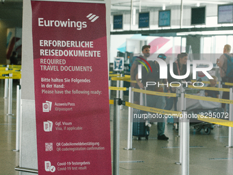 a sign of travel documents required is seen in front of Eurowings checkin counter at Cologne & Bonn airport on May 25, 2022 as Germany will...