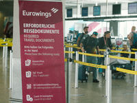 a sign of travel documents required is seen in front of Eurowings checkin counter at Cologne & Bonn airport on May 25, 2022 as Germany will...