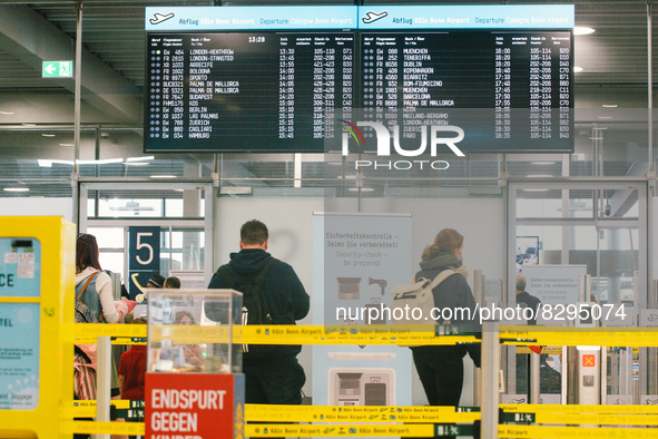 passengers are seen walking into the security checkpoint at Cologne & Bonn airport on May 25, 2022 as Germany will ease its travel restricti...