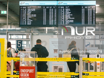 passengers are seen walking into the security checkpoint at Cologne & Bonn airport on May 25, 2022 as Germany will ease its travel restricti...