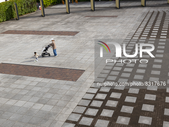 A toddler plays with his mother at a deserted plaza in Yokohama, Japan on 27 May. (