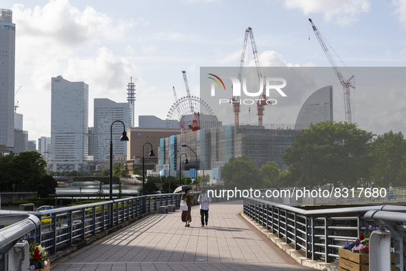 Couple with a parasol walk at seaside urban area in Yokohama, Japan on 27 May. 