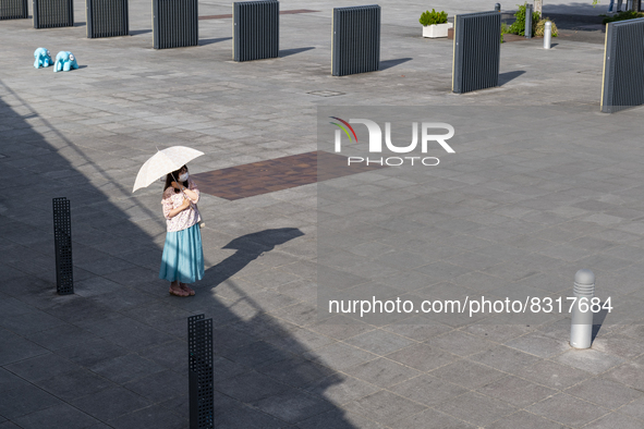 A woman with a parasol waits for her friend at seaside urban area in Yokohama, Japan on 27 May. 