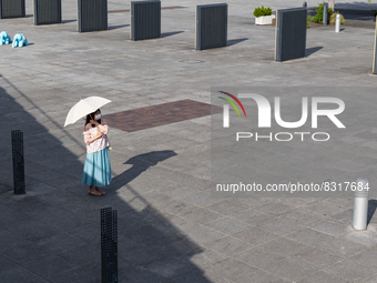 A woman with a parasol waits for her friend at seaside urban area in Yokohama, Japan on 27 May. (