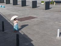 A woman with a parasol waits for her friend at seaside urban area in Yokohama, Japan on 27 May. (