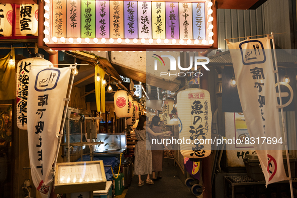 People walk along a path lined with Japanese bars at Shinbashi, Tokyo, Japan on 29 May. 