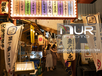 People walk along a path lined with Japanese bars at Shinbashi, Tokyo, Japan on 29 May. (