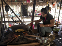 Nor Sila(22) is cooking for dinner. Egg fries are made on wood fire Malaysia is one of the most fast developing country nevertheless , the m...