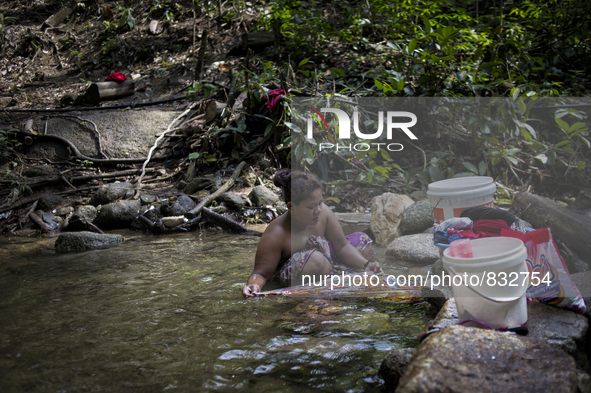 Mak Bakok(28) is washing clothes in the stream. As there is no supply of electronic , washing clothes in the stream is a party of thier usua...