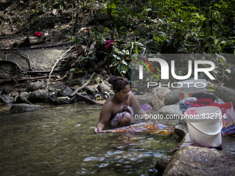 Mak Bakok(28) is washing clothes in the stream. As there is no supply of electronic , washing clothes in the stream is a party of thier usua...