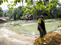 Ken Yee Lai(28) is doing finish work for bank. This pond is a main source of fish supply for thier meal. Malaysia is one of the most fast de...