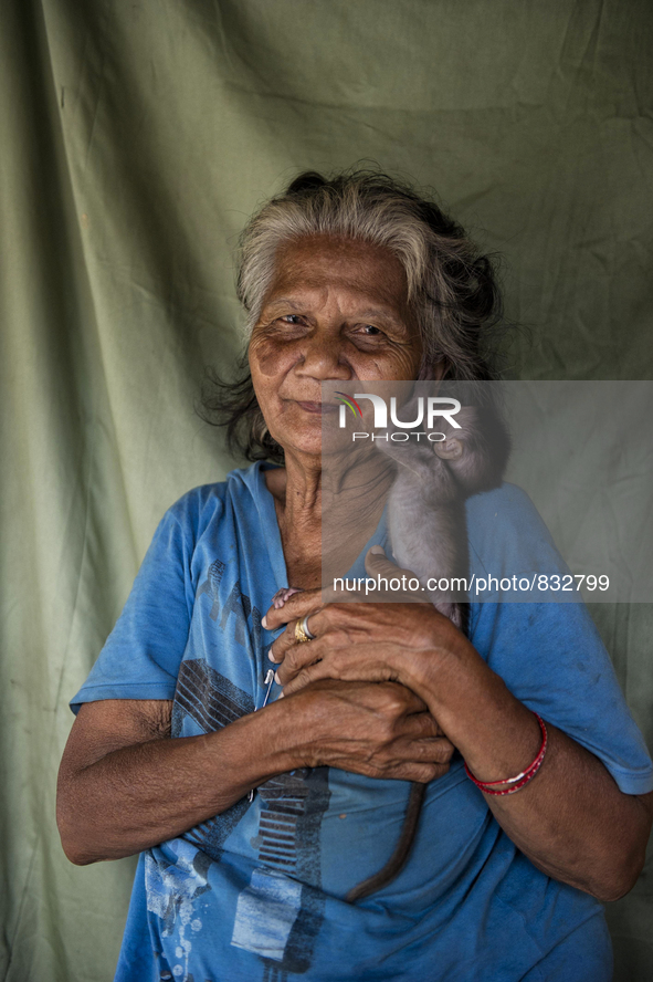 Minah Bt Raya(72) with her pet, a baby monkey.  Malaysia is one of the most fast developing country nevertheless , the modernism there is a...