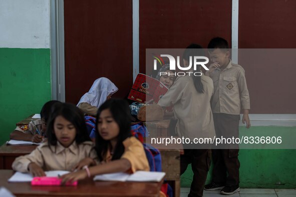 A teacher is seen teaching students at a school in Tugu Utara Village, Regency Bogor, West Java province, Indonesia on 2 June, 2022. 