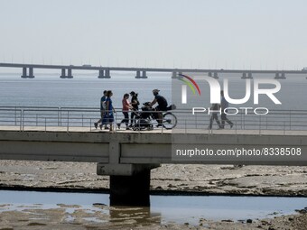 A group of people are seen performing outdoor activities in the surroundings of the Vasco da Gama walkway, close to the Tejo river. Lisbon,...