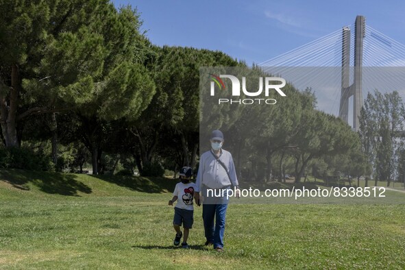 A man wearing protective mas is seen walking with a child near the  Vasco da Gama walkway, close to the Tejo river. Lisbon, 02 May 2022. A m...