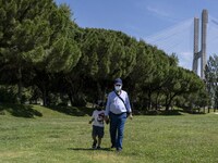 A man wearing protective mas is seen walking with a child near the  Vasco da Gama walkway, close to the Tejo river. Lisbon, 02 May 2022. A m...