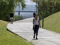 A group of people are seen performing outdoor activities in the surroundings of the Vasco da Gama walkway, close to the Tejo river. Lisbon,...