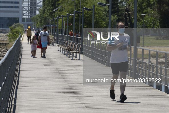 A group of people are seen performing outdoor activities in the surroundings of the Vasco da Gama walkway, close to the Tejo river. Lisbon,...