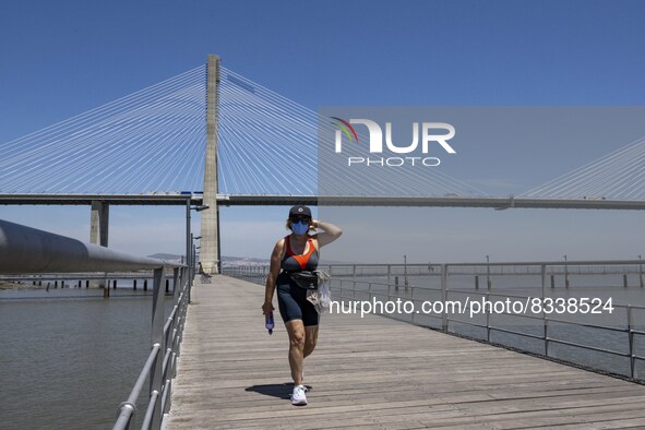 A woman wearing protective mask  performs outdoor activities in the surroundings of the Vasco da Gama walkway, close to the Tejo river. Lisb...