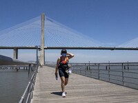 A woman wearing protective mask  performs outdoor activities in the surroundings of the Vasco da Gama walkway, close to the Tejo river. Lisb...