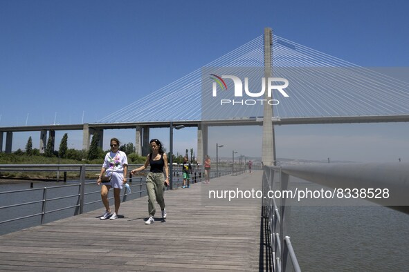 A group of people are seen performing outdoor activities in the surroundings of the Vasco da Gama walkway, close to the Tejo river. Lisbon,...