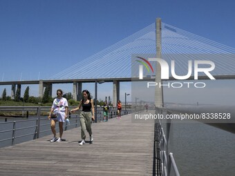 A group of people are seen performing outdoor activities in the surroundings of the Vasco da Gama walkway, close to the Tejo river. Lisbon,...