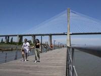 A group of people are seen performing outdoor activities in the surroundings of the Vasco da Gama walkway, close to the Tejo river. Lisbon,...