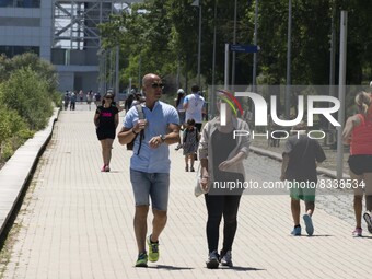 A group of people are seen performing outdoor activities in the surroundings of the Vasco da Gama walkway, close to the Tejo river. Lisbon,...