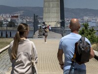 A group of people are seen performing outdoor activities in the surroundings of the Vasco da Gama walkway, close to the Tejo river. Lisbon,...