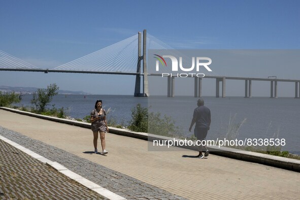 A group of people are seen performing outdoor activities in the surroundings of the Vasco da Gama walkway, close to the Tejo river. Lisbon,...