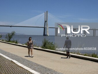 A group of people are seen performing outdoor activities in the surroundings of the Vasco da Gama walkway, close to the Tejo river. Lisbon,...