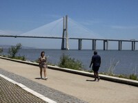 A group of people are seen performing outdoor activities in the surroundings of the Vasco da Gama walkway, close to the Tejo river. Lisbon,...