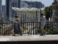 A group of people are seen performing outdoor activities in the surroundings of the Vasco da Gama walkway, close to the Tejo river. Lisbon,...