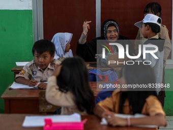 A teacher is seen teaching students at a school in Tugu Utara Village, Regency Bogor, West Java province, Indonesia on 2 June, 2022. (