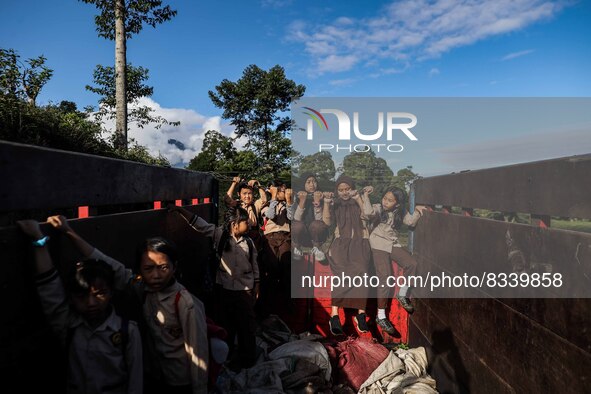 Students are huddling together in a truck to going school in Tugu Utara Village, Regency Bogor, West Java province, Indonesia on 2 June, 202...