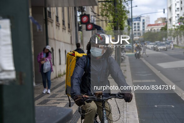 A delivery man wearing a protective mask is seen riding his bicycle on a street in the Saldanha district. Lisbon, June 03, 2022. Portugal ha...