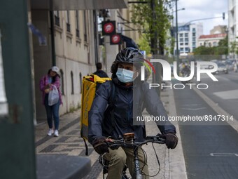 A delivery man wearing a protective mask is seen riding his bicycle on a street in the Saldanha district. Lisbon, June 03, 2022. Portugal ha...