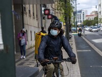 A delivery man wearing a protective mask is seen riding his bicycle on a street in the Saldanha district. Lisbon, June 03, 2022. Portugal ha...