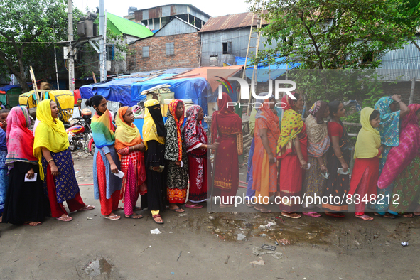 Slum dwellers wait to receive a Booster Dose of COVID-19 vaccine at a makeshift vaccination center during a national campaign at Karail Slum...