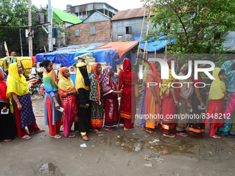 Slum dwellers wait to receive a Booster Dose of COVID-19 vaccine at a makeshift vaccination center during a national campaign at Karail Slum...