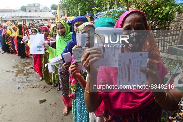 Slum dwellers wait to receive a Booster Dose of COVID-19 vaccine at a makeshift vaccination center during a national campaign at Karail Slum...