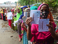 Slum dwellers wait to receive a Booster Dose of COVID-19 vaccine at a makeshift vaccination center during a national campaign at Karail Slum...