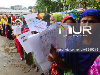 Slum dwellers wait to receive a Booster Dose of COVID-19 vaccine at a makeshift vaccination center during a national campaign at Karail Slum...