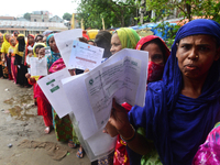 Slum dwellers wait to receive a Booster Dose of COVID-19 vaccine at a makeshift vaccination center during a national campaign at Karail Slum...