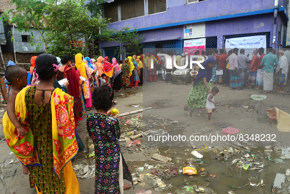 Slum dwellers wait to receive a Booster Dose of COVID-19 vaccine at a makeshift vaccination center during a national campaign at Karail Slum...